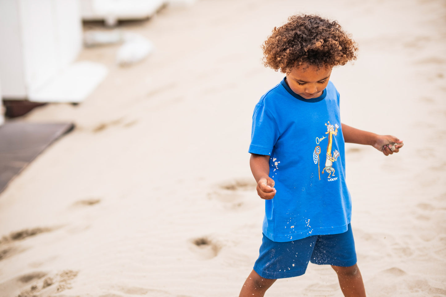 Kind draagt blauwe pyjama met giraf
