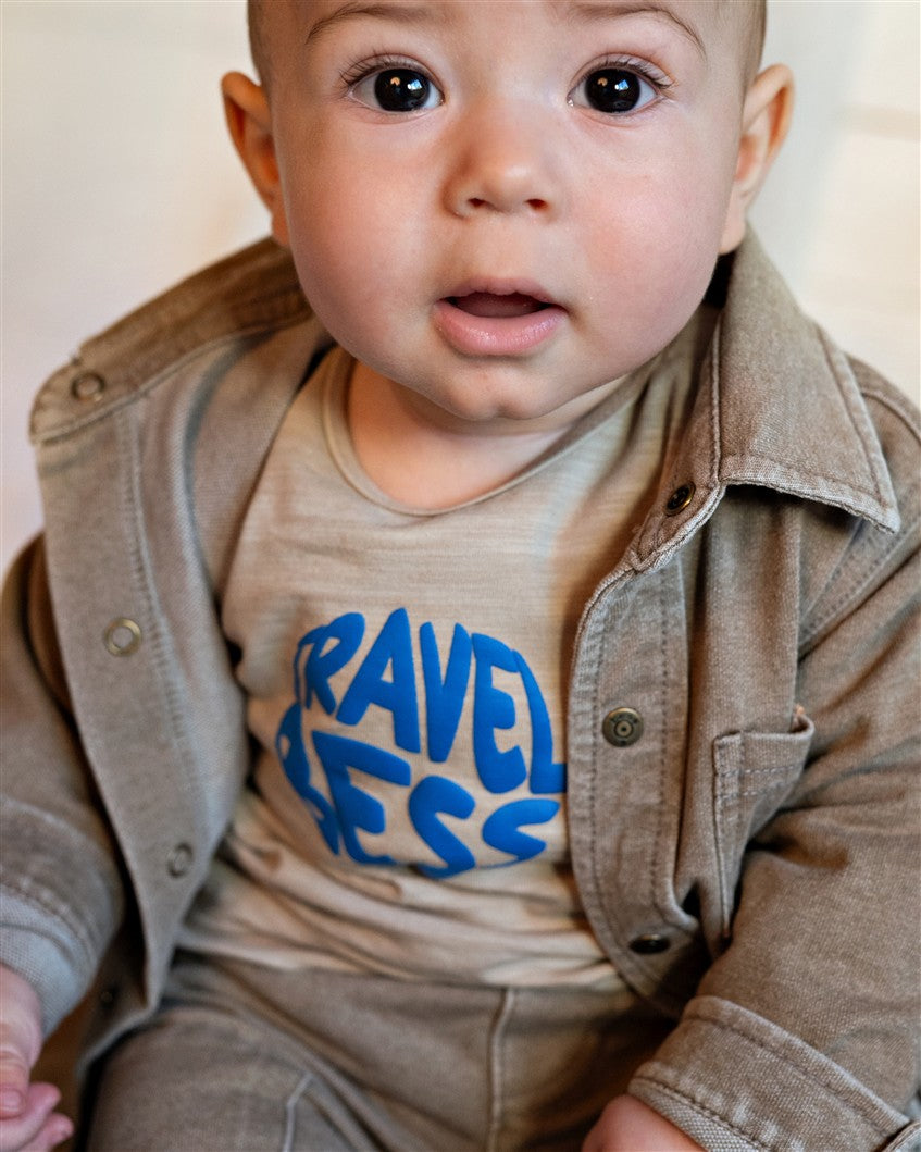 Lichtbruin babyshirt met stoere tekstprint op de voorkant.
