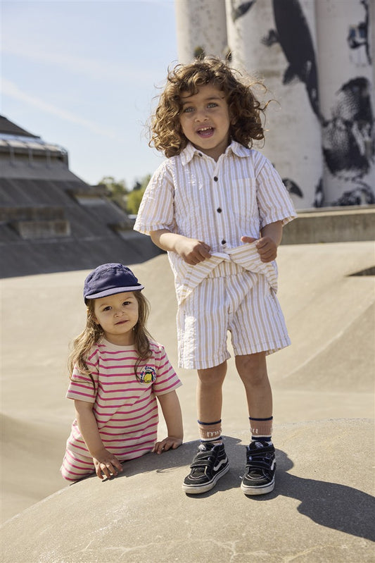 Kind draagt ecru-wit gestreepte short