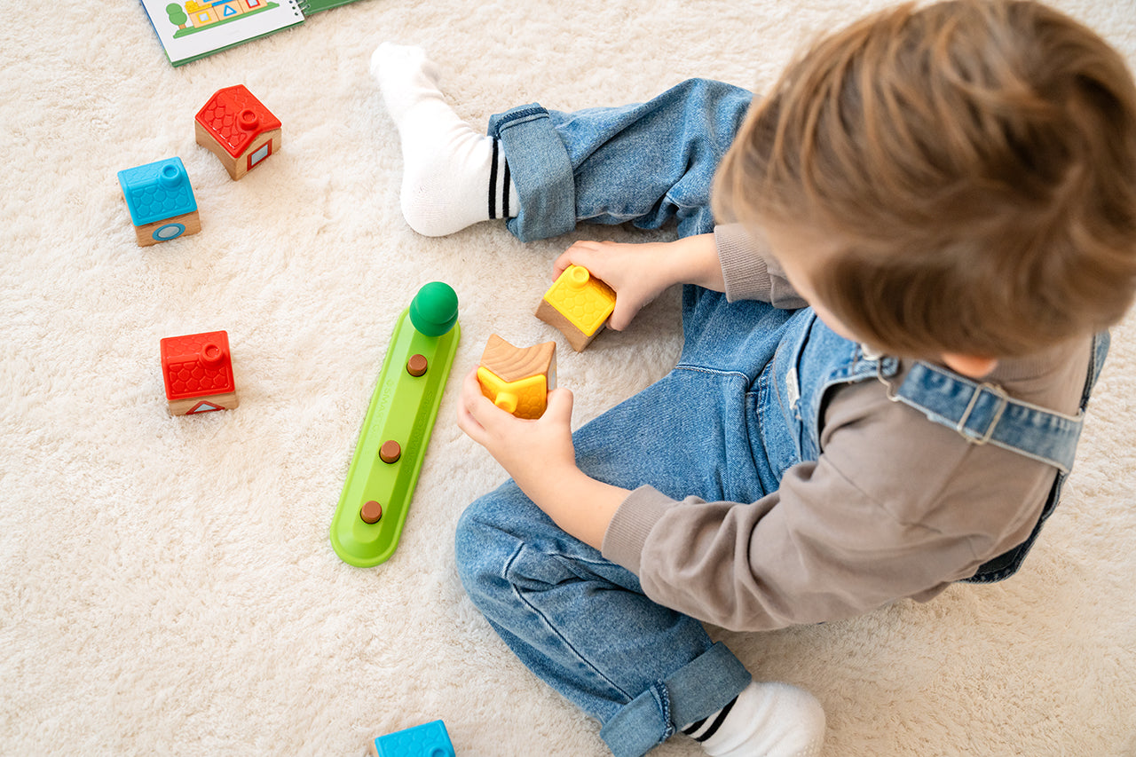 jongen speelt met stapel dorp