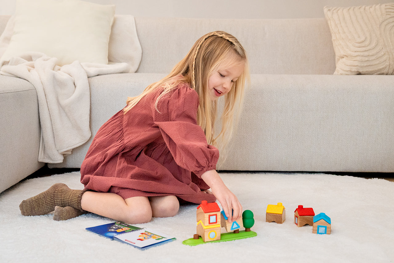 meisje speelt stapeldorp van smartgames