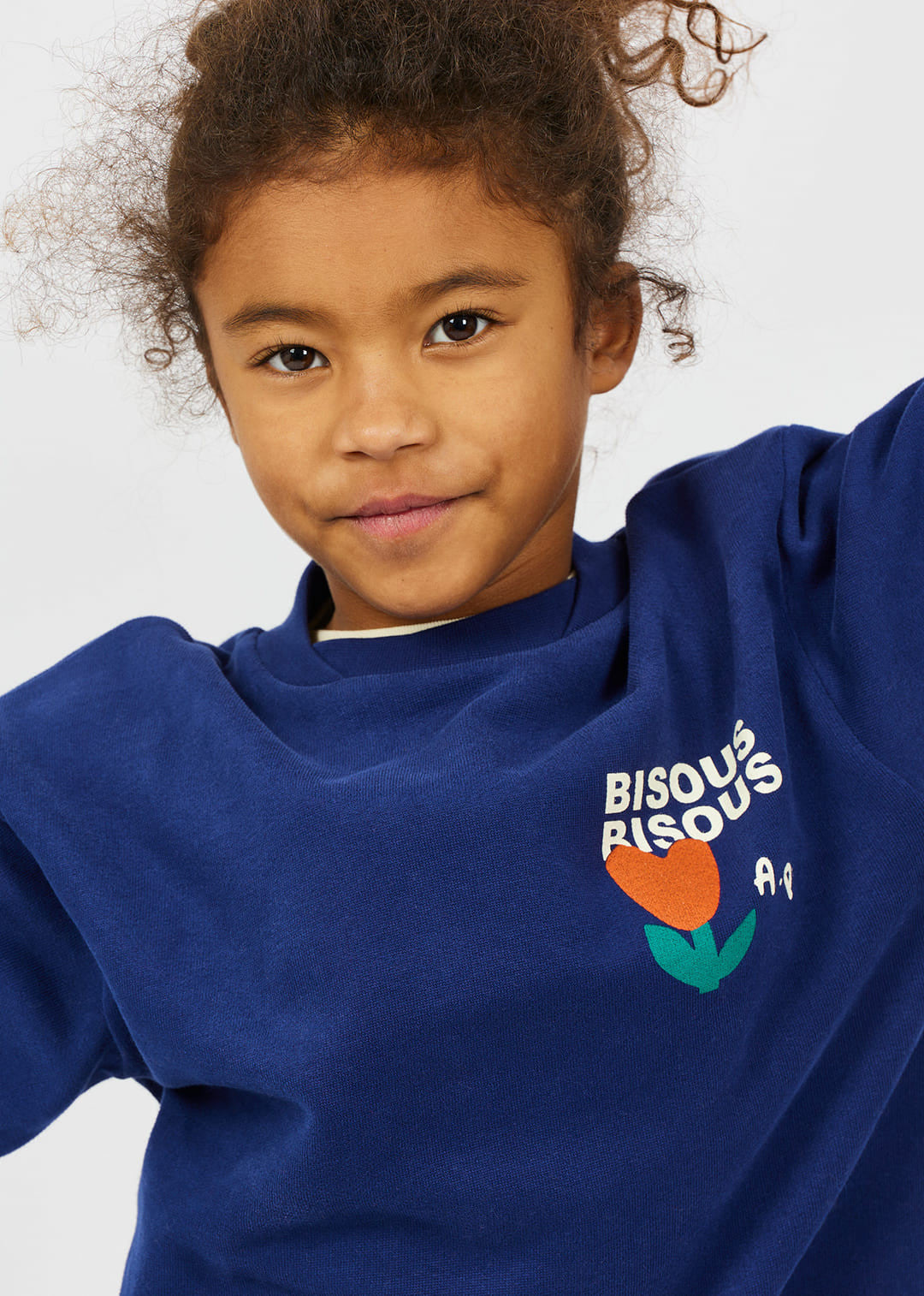 meisje draagt sweater bisous van arsene