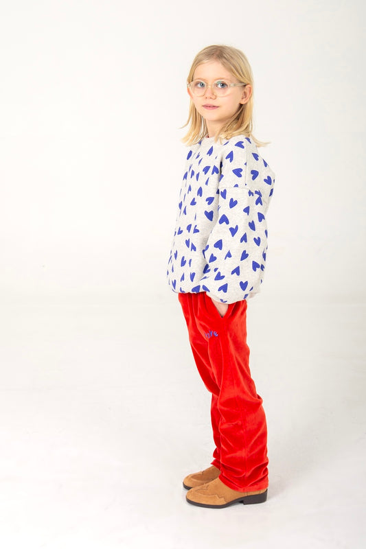Lötiekids meisjes sweater met blauwe hartjes op een lichtgrijze achtergrond.