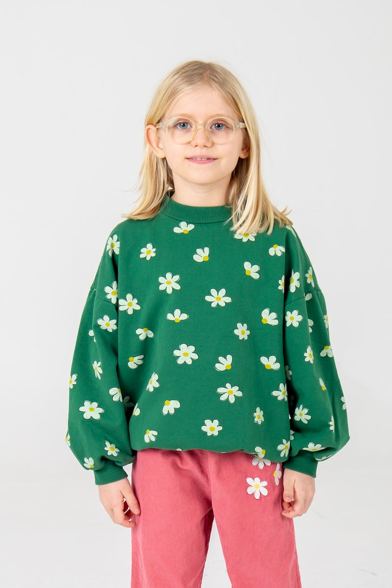 Meisjes sweater met witte madeliefjes op een groene achtergrond.