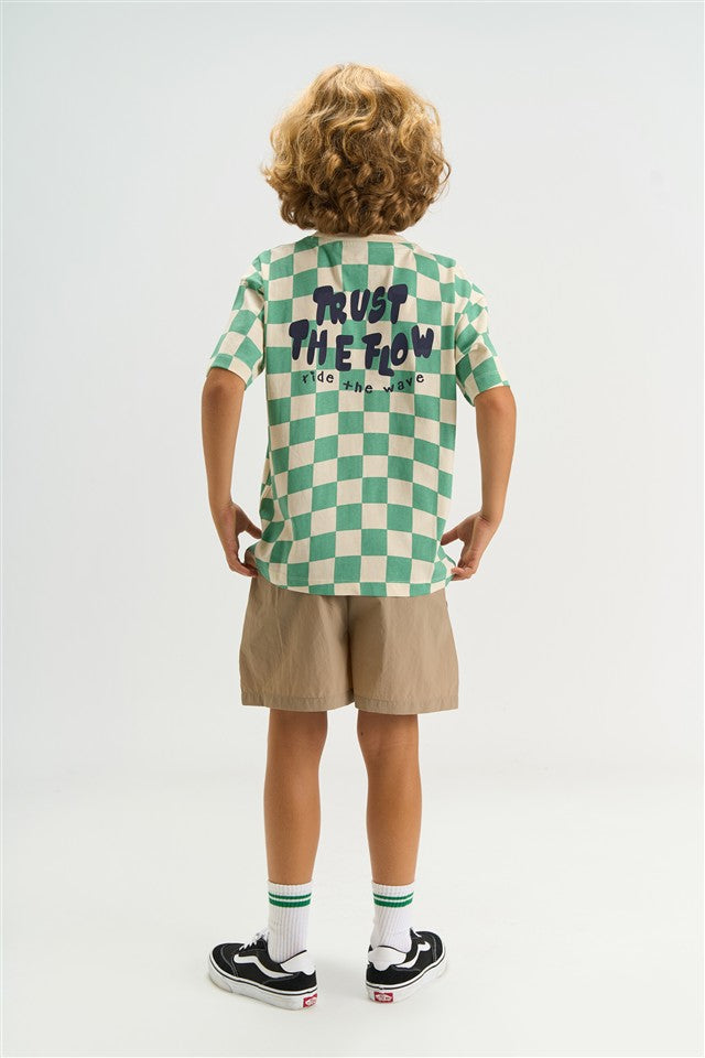 jongen draagt tshirt met dambordpatroon en opdruk op de rugzijde van the new