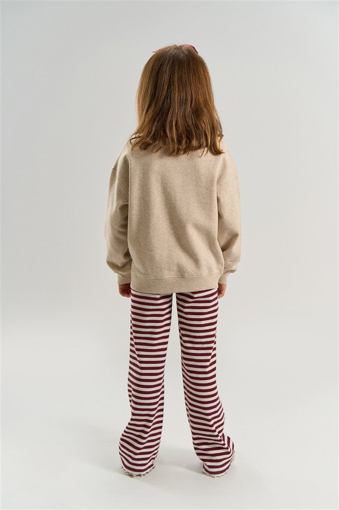 Trendy meisjes sweater in neutrale kleur met grafische opdruk.