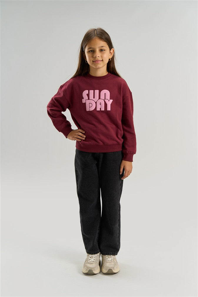 Meisjessweater in Burgundy kleur met tekstprint op de voorkant.